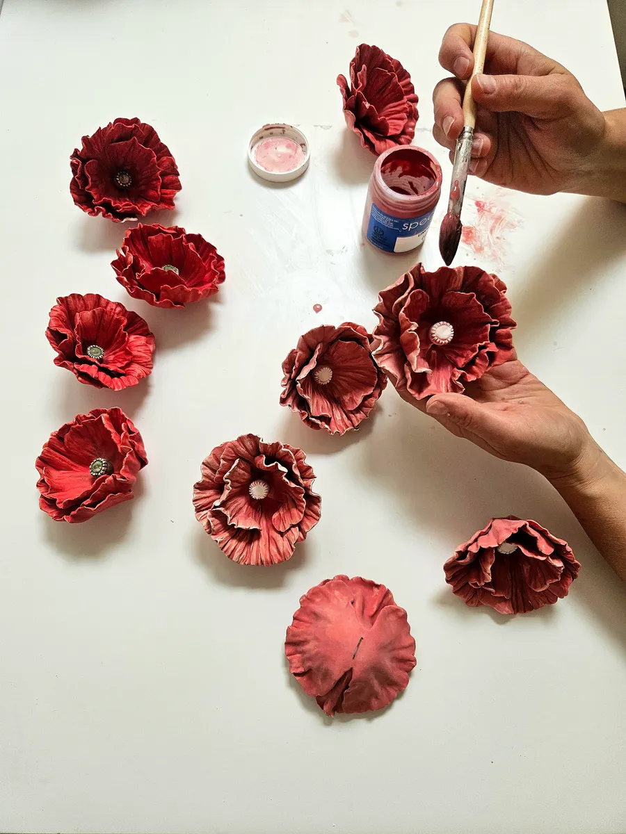 Handmade porcelain poppy sculptures being painted in the studio